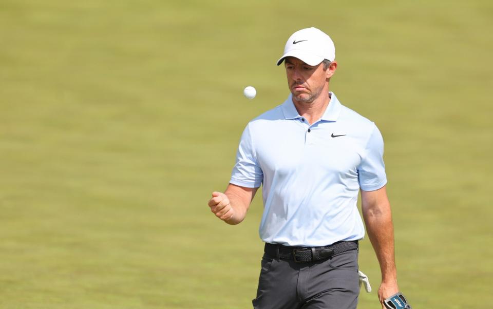 Rory McIlroy of Northern Ireland tosses his ball on the 16th green