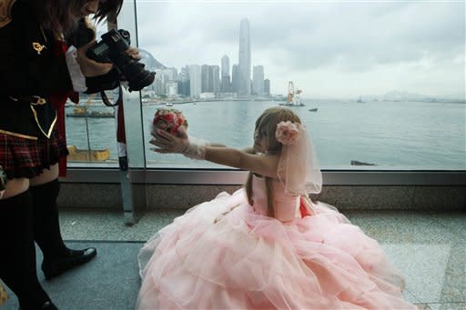 A young participant wearing her outfit featuring an animation character poses for a photo at the annual Comics Festival and Game Fair in Hong Kong Friday, July 27, 2012. The fair is expected to attract more than 170 local and international exhibitors displaying their latest comics, video games and accessories. (AP Photo/Kin Cheung)