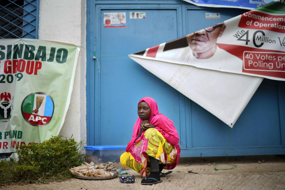 A Nigerian woman sells peanuts outside Incumbent President Muhammadu Buhari's campaign headquarters in Abuja, Nigeria, Tuesday Feb. 26, 2019.Anxious Nigerians on Tuesday awaited a second day of state-by-state announcements of presidential election results in a race described as too close to call. Buhari is facing opposition presidential candidate Atiku Abubakar. (AP Photo/Jerome Delay)