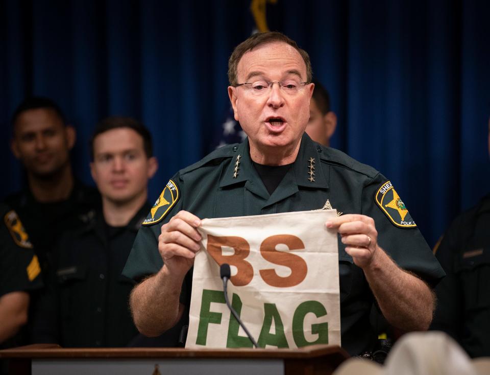 Polk County Sheriff Grady Judd holds up a BS Flag during a press conference with Gov. Ron DeSantis at the Sheriff's Operations Center in Winter Haven on Friday.