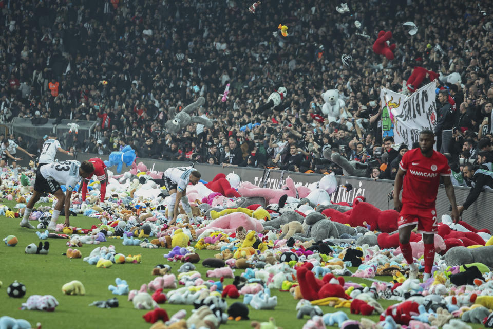 FILE - Fans throw toys onto the pitch to be donated to children affected by the powerful earthquake on Feb. 6 on southeast Turkey, during the Turkish Super League soccer match between Besiktas and Antalyaspor at the Vodafone stadium, in Istanbul, Turkey, Sunday, Feb. 26, 2023. In Ukraine and Turkey, the national soccer league titles can be decided in showdown games this month between the top two teams in the standings. That the leagues are set to be completed at all is remarkable. (AP Photo, File)