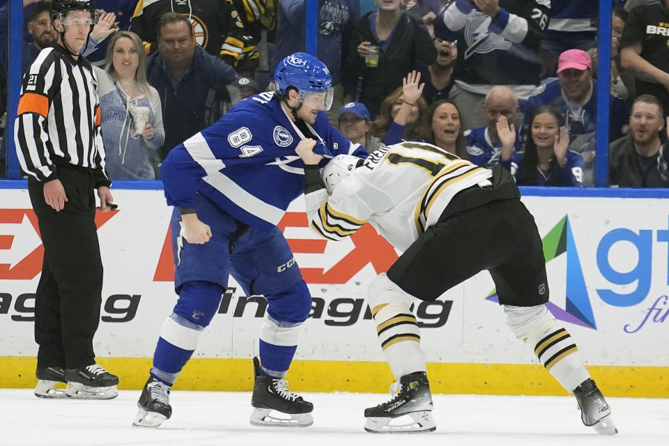 Tampa Bay Lightning left wing Tanner Jeannot (84) and Boston Bruins center Trent Frederic (11) fight during the first period of an NHL hockey game Wednesday, March 27, 2024, in Tampa, Fla. (AP Photo/Chris O'Meara)
