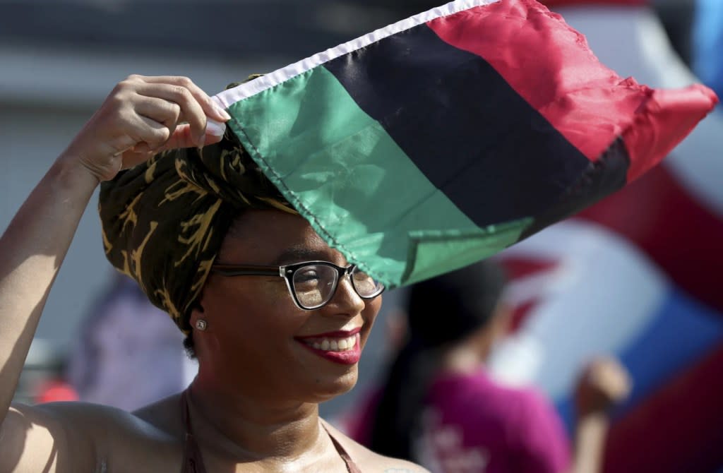 Crystal Baziel holds the Pan-African flag Monday, June 19, 2023, during Reedy Chapel A.M.E Church’s annual Juneteenth Family Fun Day, in Galveston, Texas. (Jennifer Reynolds/The Galveston County Daily News via AP, File)