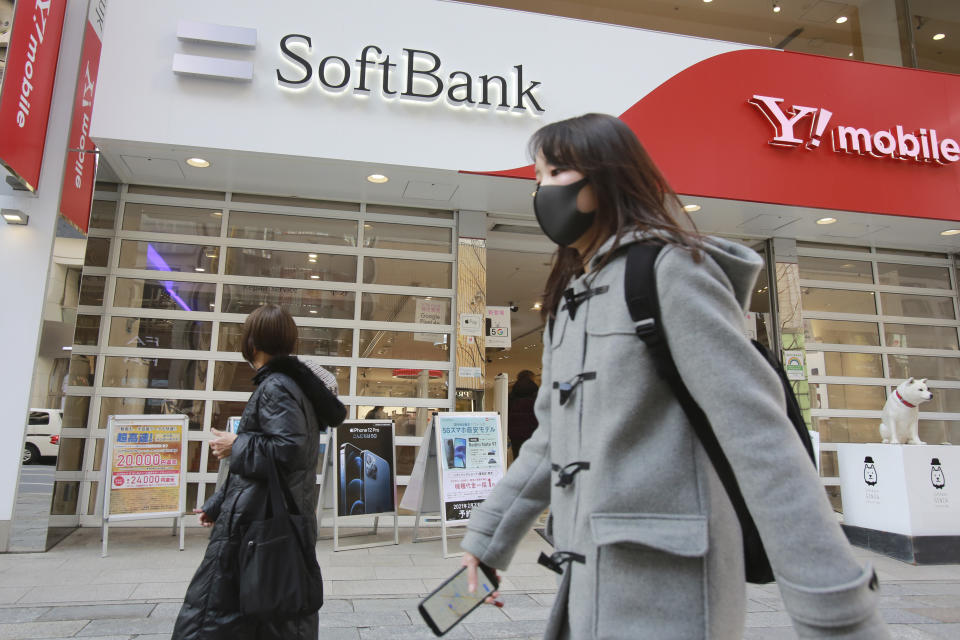 People walk by a SoftBank shop in Tokyo, Monday, Feb. 8, 2021. Japanese telecommunications and technology conglomerate Softbank Group Corp. reported Monday a whopping 1.17 trillion yen ($11 billion) profit for the October-December quarter as its investments rose in value(AP Photo/Koji Sasahara)