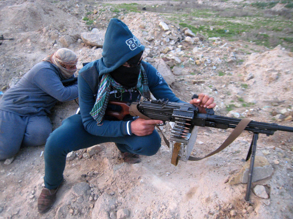 In this Thursday, Jan. 23, 2014 photo, gunmen take combat positions in Fallujah, Iraq. Islamic militants controlling a mainly Sunni area west of Baghdad are so well-armed that they could occupy the capital, members of Iraq's al-Qaida branch - known as the Islamic State of Iraq and the Levant - have taken over parts of Ramadi, the capital of the largely Sunni western province of Anbar. (AP Photo)