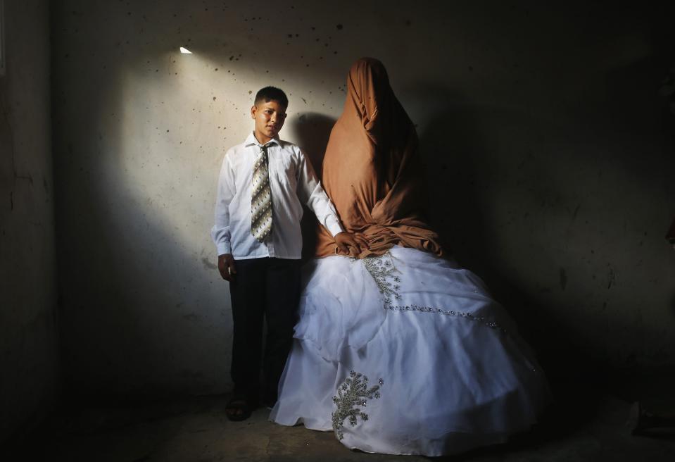 RNPS - PICTURES OF THE YEAR 2013 - Young Palestinian groom Ahmed Soboh, 15 and his bride Tala, 14, stand inside Tala's house which was damaged during an Israeli strike in 2009, during their wedding party in the town of Beit Lahiya, near the border between Israeli and northern Gaza Strip September 24, 2013. REUTERS/Mohammed Salem (GAZA - Tags: POLITICS CIVIL UNREST TPX)