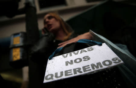 A woman talks on her cell phone as she carries a sign that reads "We want us alive" during a demonstration to demand policies to prevent gender-related violence, Argentina, October 19, 2016. REUTERS/Marcos Brindicci