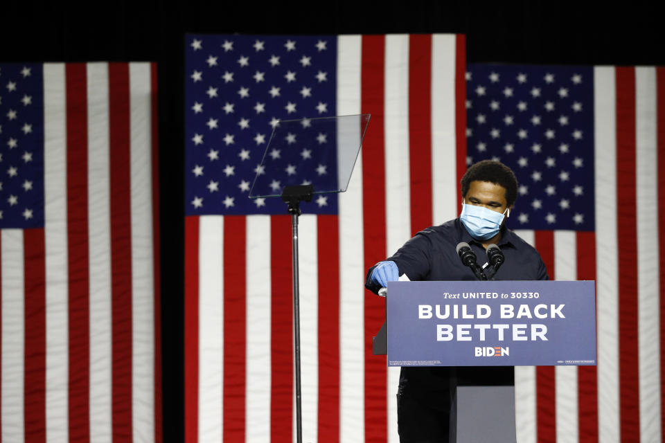 Caliph Mathis wipes down the lecture before Democratic presidential candidate, former Vice President Joe Biden arrives to speak at a campaign event, Tuesday, July 14, 2020, in Wilmington, Del. (AP Photo/Patrick Semansky)