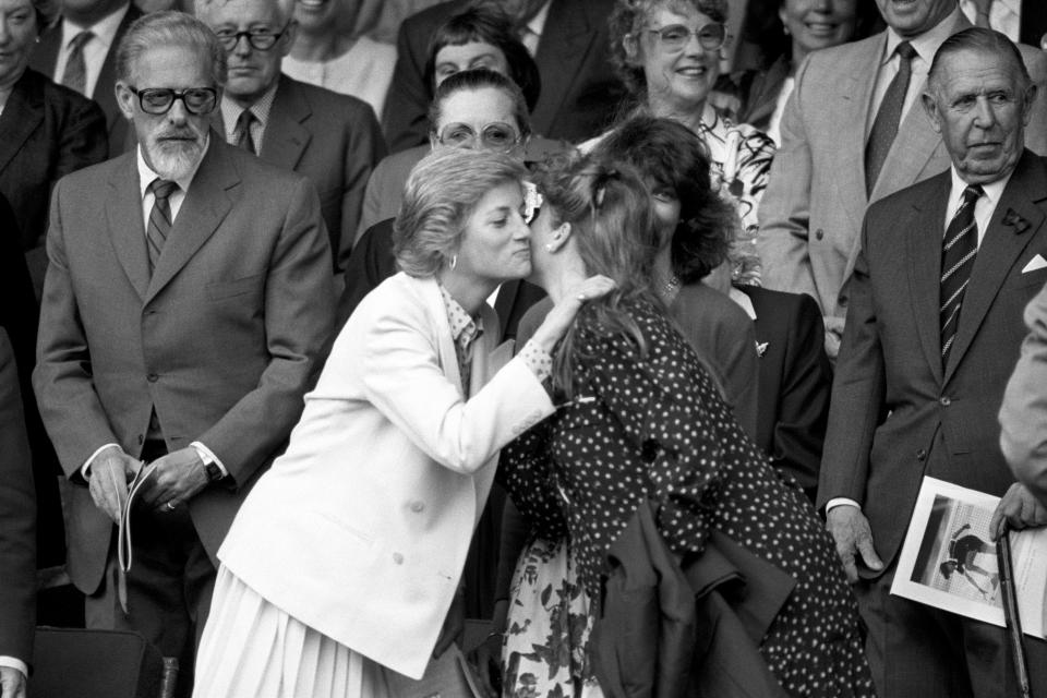 Diana Princess of Wales kisses The Duchess of York as they meet in the Royal Box on Centre Court at Wimbledon.