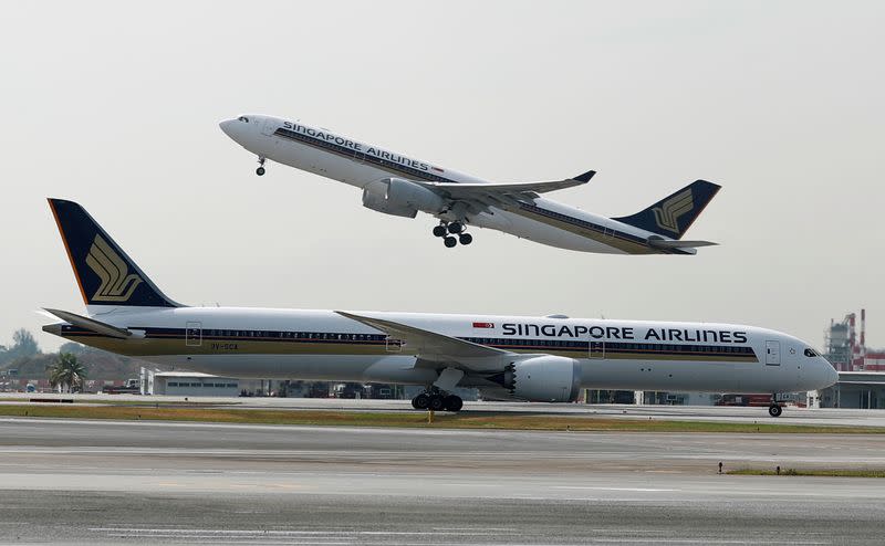 FILE PHOTO: A Singapore Airlines Airbus A330 plane takes off behind a Boeing 787 Dreamliner at Changi Airport in Singapore