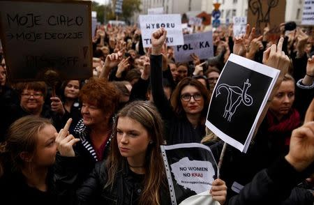 Women gesture as people gather in an abortion rights campaigners' demonstration to protest against plans for a total ban on abortion in front of the ruling party Law and Justice (PiS) headquarters in Warsaw, Poland October 3, 2016. REUTERS/Kacper Pempel