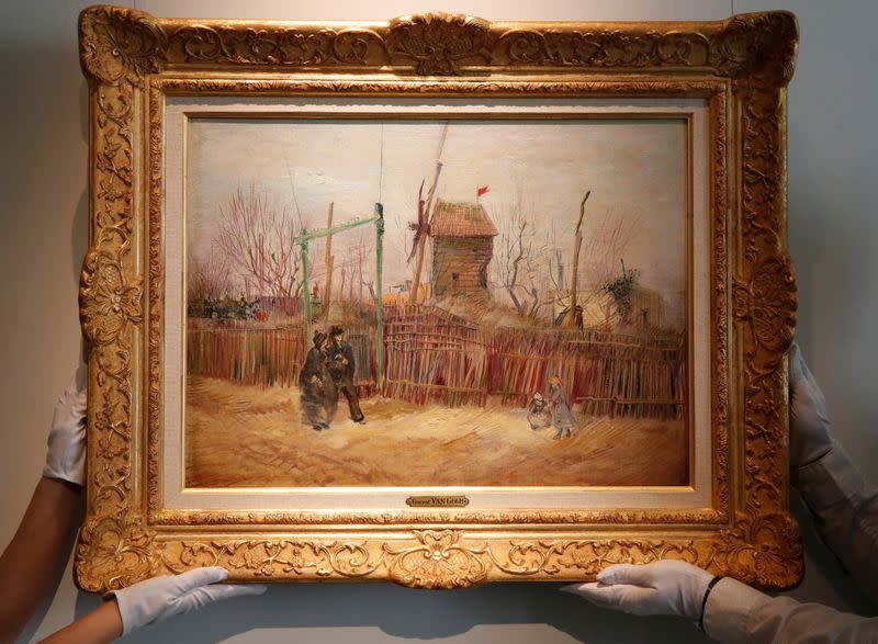 Sotheby's Paris employees pose with the painting "Scene de rue a Montmartre" by Dutch painter Vincent Van Gogh