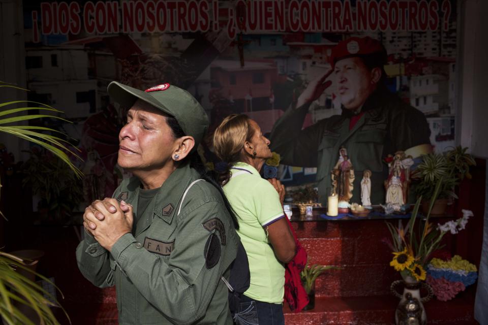 Marisol Perez, Venezuelan Army specialist, cries while visiting a chapel to mark the death of Venezuela's late President Hugo Chavez, in Caracas, Venezuela, Wednesday, March 5, 2014. Wednesday's anniversary of Chavez's death follows weeks of sometimes violent protests that the government says have left 18 dead. To mark Chavez's passing, who died March 5, 2013 at the age of 58, President Nicolas Maduro has decreed a 10-day-long commemoration. (AP Photo/Rodrigo Abd)