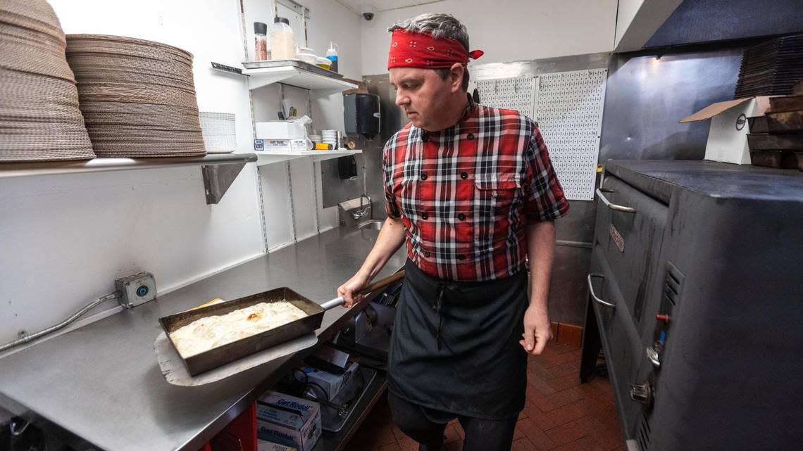 Matty Evans, chef of Rise Up Pizza, pulls a partially completed Detroit-style pizza from the oven within the kitchen of the restaurant’s new location within Horse & Jockey Pub on Cheapside, November 9, 2023. Marcus Dorsey/mdorsey@herald-leader.com