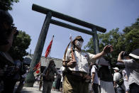 Visitors in Japanese Imperial army and navy uniforms enter Yasukuni Shrine, which honors Japan's war dead, Saturday, Aug. 15, 2020, in Tokyo. Japan marked the 75th anniversary of the end of World War II. (AP Photo/Eugene Hoshiko)