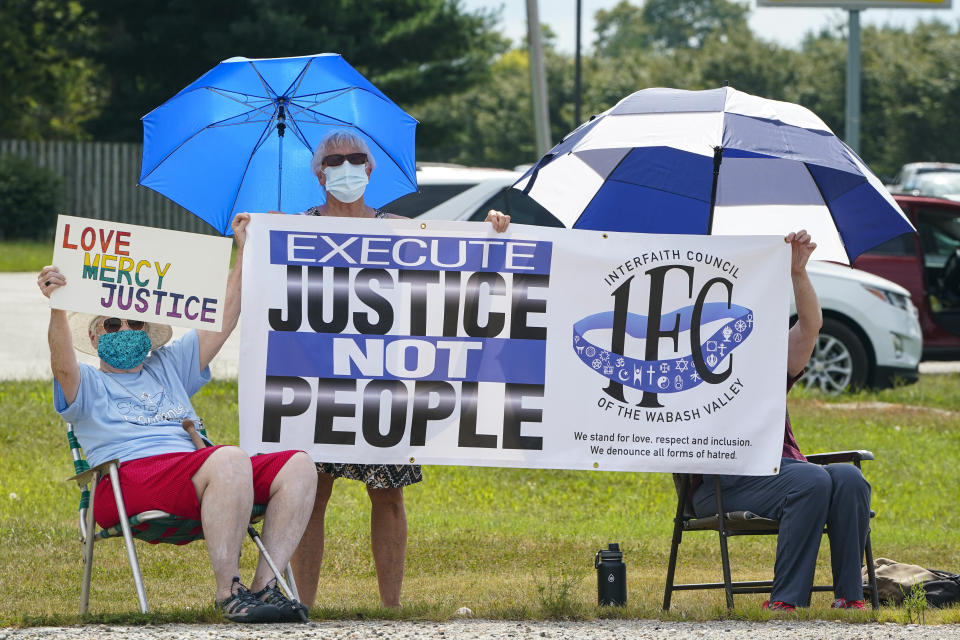 Protesters gather across from the the federal prison complex in Terre Haute, Ind., Friday, Aug. 28, 2020. Keith Dwayne Nelson, who was convicted of kidnapping, raping and murdering at 10-year-old Kansas girl, is schedule to be executed Friday. (AP Photo/Michael Conroy)