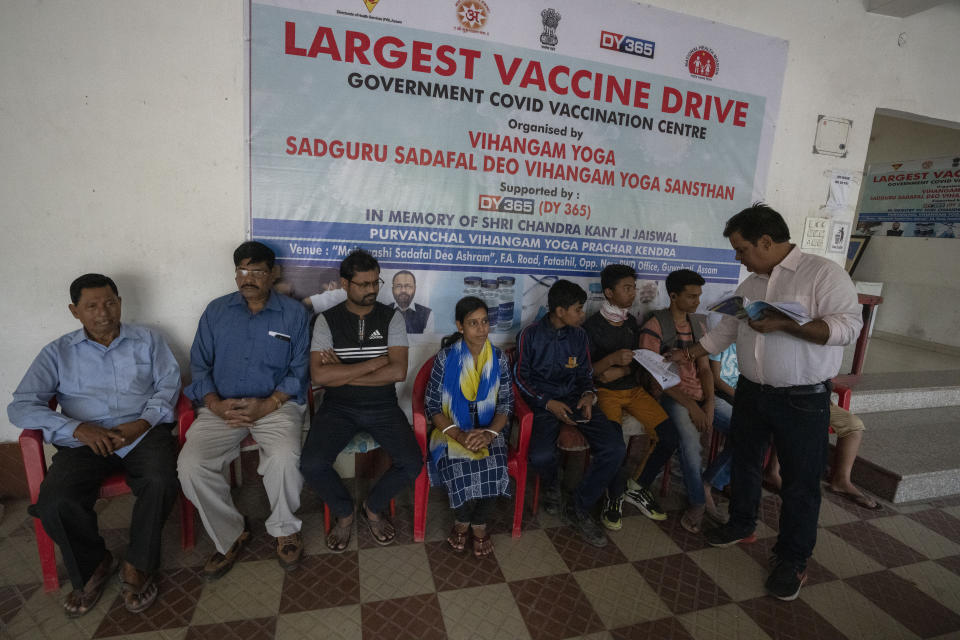 People sit in queue to receive their third dose of vaccine for COVID-19 at a private vaccination center in Gauhati, India, Sunday, April 10, 2022. India began offering booster doses of COVID-19 vaccine to all adults on Sunday but limited free shots at government centers to front-line workers and people over age 60. (AP Photo/Anupam Nath)