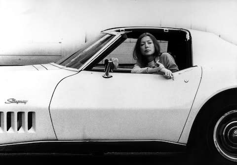 Author Joan Didion sitting in her white Stingray car - Credit: Julian Wasser/Getty