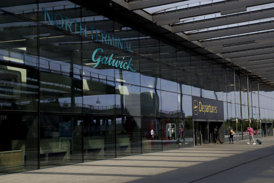 Passengers walk into the Departures entrance at the North Terminal of Gatwick Airport near Crawley, just south of London, Wednesday, July 22, 2020. With all schools now closed, Friday would normally be the busiest departure day of the year for London’s Gatwick Airport with families heading off to the sun-soaked beaches in southern Europe. Not this year as the coronavirus pandemic has meant many have opted against making their annual summer migration to countries like Spain and Greece. Gatwick would in any normal year be expecting to fly some 85,000 holidaymakers on Friday alone. It expects less than 10,000 passenger departures on Friday. (AP Photo/Matt Dunham)