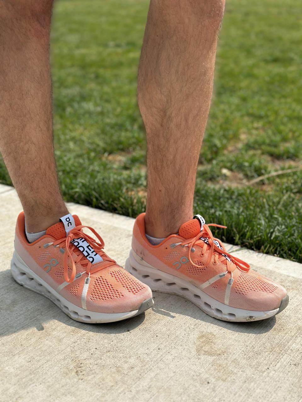 man wearing orange running shoes ON Cloudsurfer on sidewalk, ON cloudsurfer running shoes review
