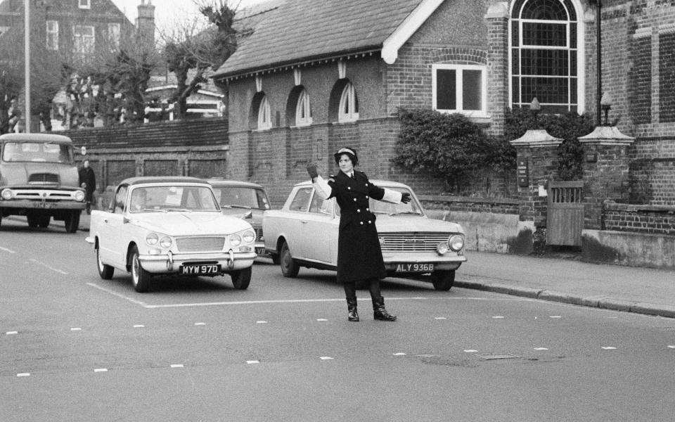 Britain's first Traffic Warden to control traffic as opposed to booking cars for parking offences, Mrs Joyce Roffey, on point duty at a busy crossroads in Croydon, Surrey, the junction of Park Lane and Coombe Road, 2nd January 1967. (Photo by Eric Harlow/Mirrorpix/Getty Images)  - Getty