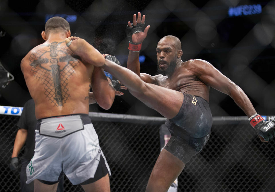 Jon Jones, right, lands a kick on Thiago Santos during their during their light heavyweight mixed martial arts title bout at UFC 239 on Saturday, July 6, 2019, in Las Vegas. Jones won by split decision. (AP Photo/Eric Jamison)