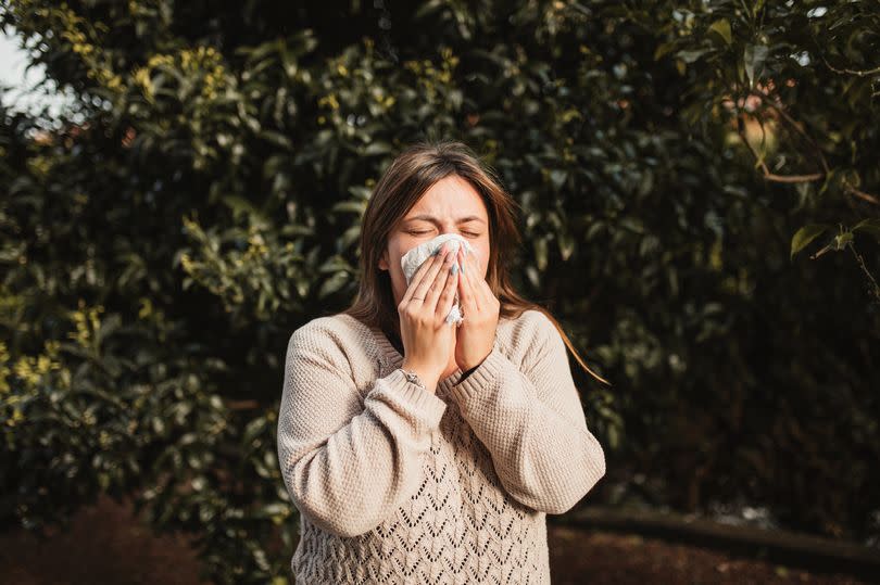 adult woman in nature suffering from allergy