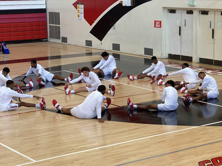 Westchester basketball players stretch on the court before a game on May 7, 2021.