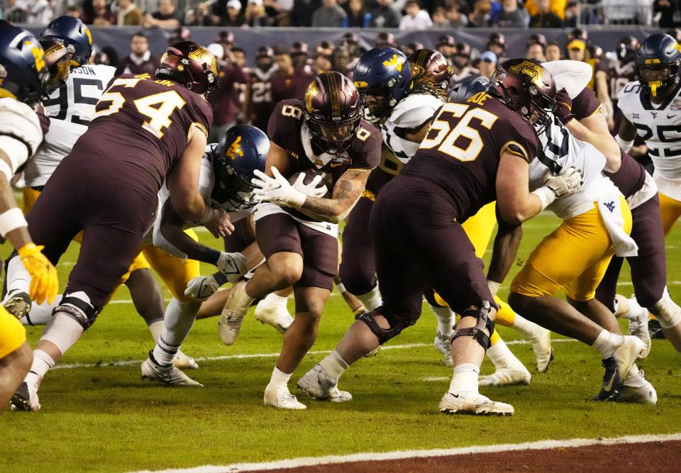 Dec 28, 2021; Phoenix, Arizona, USA; Then with Minnesota, running back Ky Thomas (8) rushes for a touchdown against West Virginia during the Guaranteed Rate Bowl at Chase Field.