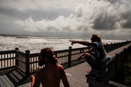 Steven Tyson and Blaize Carroll hang out at Marineland as they watch beach waves come closer to them caused by Hurricane Dorian making its' way North in St. Johns County in St. Augustine