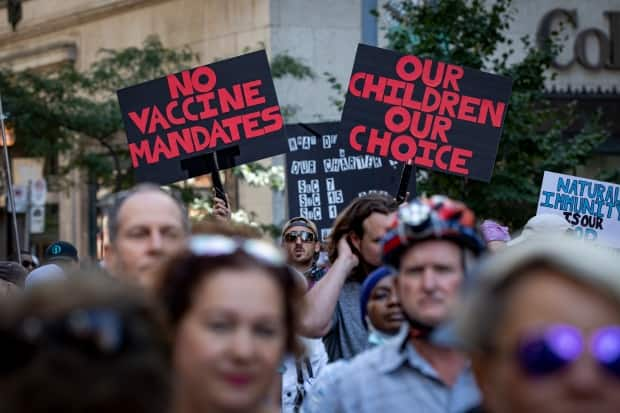 Hundreds of people gathered in front of Toronto police headquarters for a demonstration against mandatory COVID-19 vaccinations on Thursday, the day after Premier Doug Ford announced a vaccine passport plan. Protests have also been held in other Canadian cities. (Evan Mitsui/CBC - image credit)