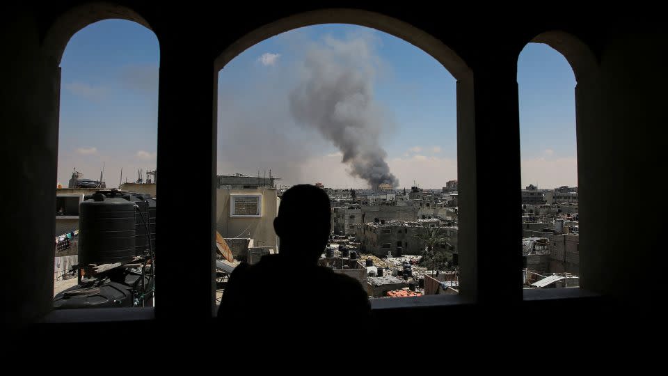 A Palestinian man watches smoke rise following Israeli strikes in the eastern part of Rafah on May 7. - Hatem Khaled/Reuters