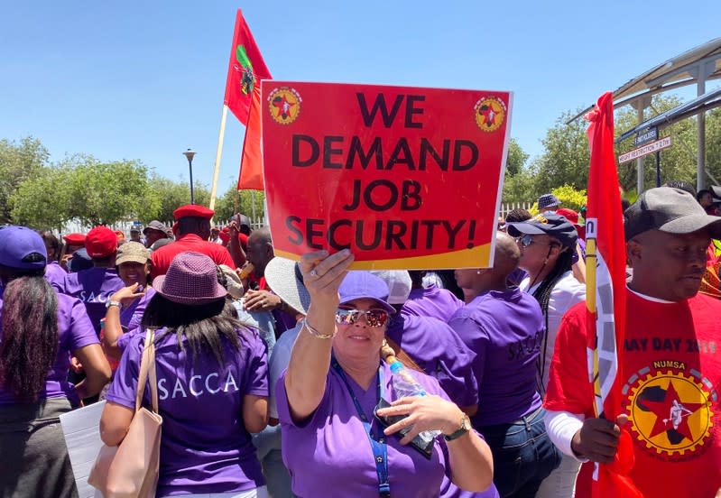 Workers of South African Airways (SAA) hold placards during a strike over wages and job cuts at SAA headquarters in Kempton Park