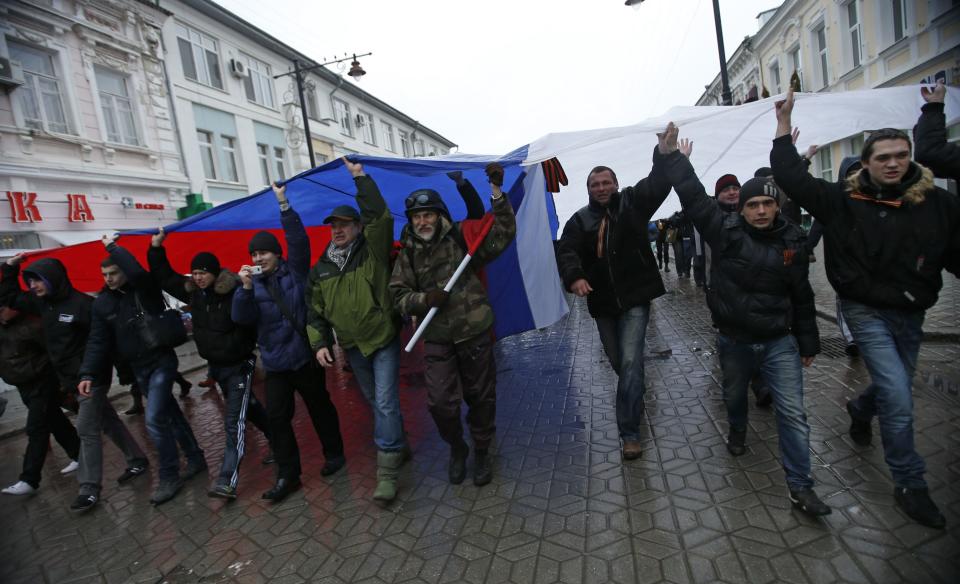 People march under giant Russian flag during a pro-Russian rally in Simferopol