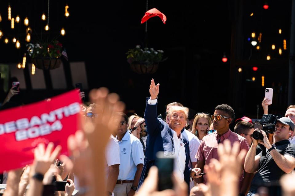 Former President Donald Trump tosses a hat in the air while supporters cheer for him on Aug. 12.<span class="copyright">Demetrius Freeman—The Washington Post/Getty Images</span>