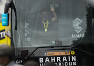 A member of the Bahrain Victorious team closes the curtains in team the bus prior to the eighteenth stage of the Tour de France cycling race over 129.7 kilometers (80.6 miles) with start in Pau and finish in Luz Ardiden, France,Thursday, July 15, 2021. The Bahrain Victorious team competing at the Tour de France says it was raided by French police on the eve of Thursday's stage. (AP Photo/Christophe Ena)