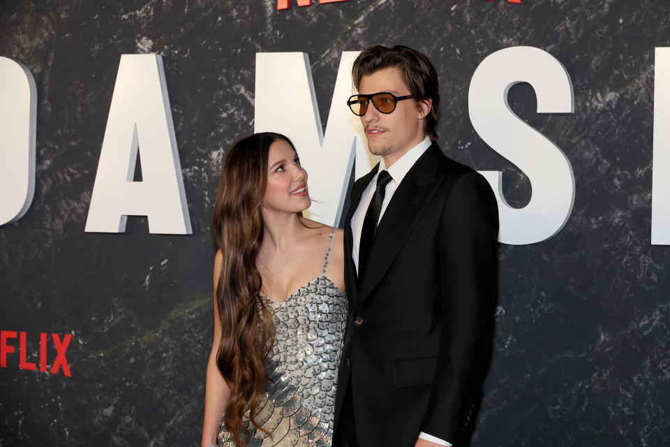 Millie Bobby Brown looking up at Jake Bongiovi as they stand on the red carpet