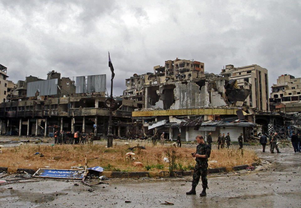 Syrian government forces inspect damages in Homs, Syria, Thursday, May 8, 2014. Carrying their rifles and small bags of belongings, hundreds of exhausted Syrian rebels withdrew Wednesday from their last remaining strongholds in the heart of Homs, surrendering to President Bashar Assad a bloodstained city that was once the center of the revolt against him. (AP Photo)