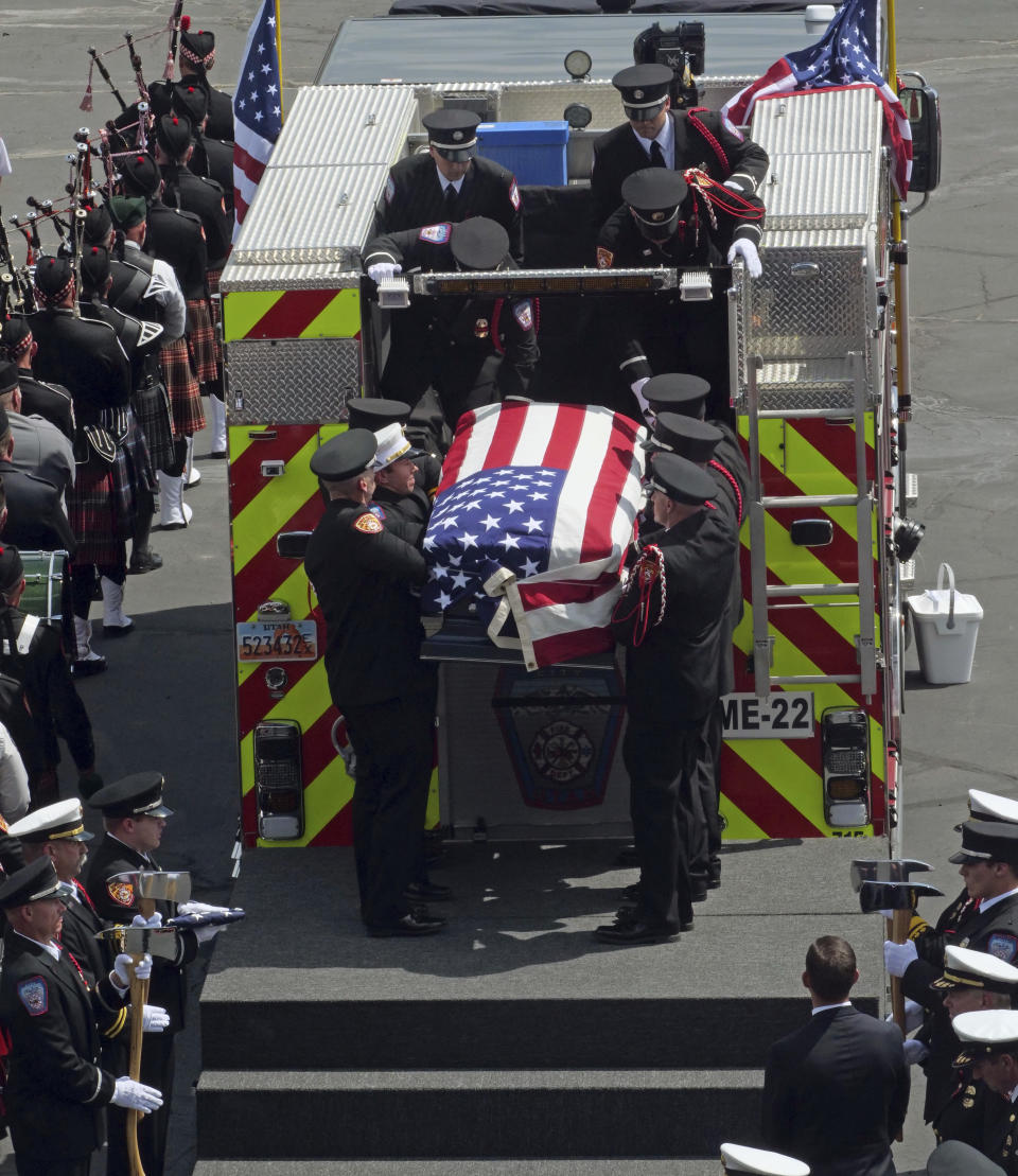 Firefighters carry the casket of Battalion Chief Matt Burchett, of the Draper Fire Department, to the back of a fire truck during funeral services Monday, Aug. 20, 2018, in West Valley City, Utah. Burchett died Aug. 13 from falling tree debris after a load of fire retardant was dropped on the area where he was working. (AP Photo/Rick Bowmer)