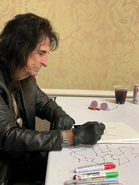 Alice Cooper sketches a cat during the Spooky Empire convention in Orlando in May 2024.