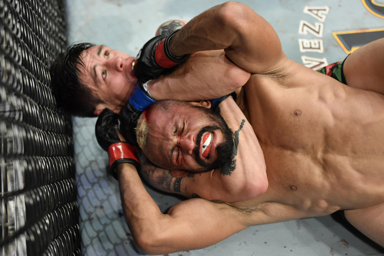 GLENDALE, ARIZONA - JUNE 12: (L-R) Brandon Moreno of Mexico secures a rear choke submission against Deiveson Figueiredo of Brazil in their UFC flyweight championship fight during the UFC 263 event at Gila River Arena on June 12, 2021 in Glendale, Arizona. (Photo by Jeff Bottari/Zuffa LLC)