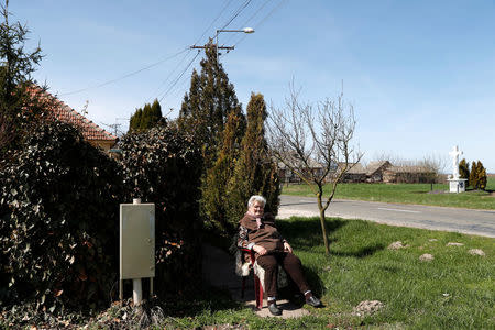 Terez Majsztrovics, 84, sits next to her house in the village of Bacsszentgyorgy, Hungary, April 3, 2018. REUTERS/Bernadett Szabo