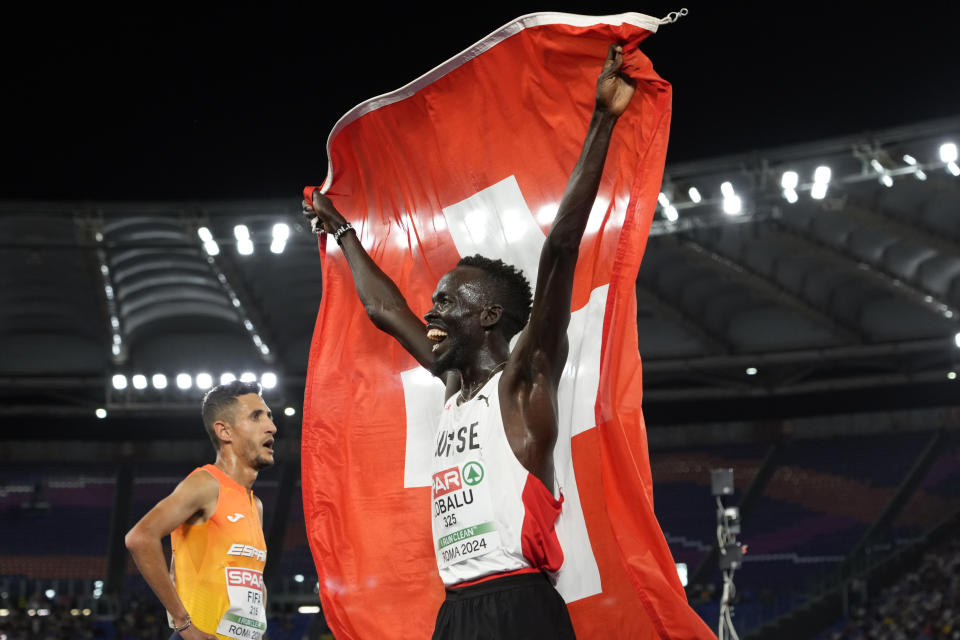 Dominic Lokinyomo Lobalu, of Switzerland, celebrates after winning the gold medal in the men's 10000 meters A-race at the European Athletics Championships in Rome, Wednesday, June 12, 2024. (AP Photo/Stefano Costantino)