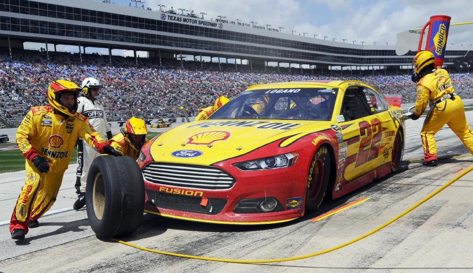 Joey Logano (22) gets fuel and tires during a pit stop during the NASCAR Sprint Cup series auto race at Texas Motor Speedway, Monday, April 7, 2014, in Fort Worth, Texas. (AP Photo/Ralph Lauer)