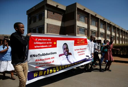 Striking healthcare workers march to protest over the disappearance of Peter Magombeyi, the leader of their union, outside a hospital in Harare