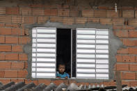 A boy looks on from his window at the Paraisopolis slum during a quarantine imposed by the the state government to help curb the spread of the new coronavirus in Sao Paulo, Brazil, Wednesday, April 8, 2020. (AP Photo/Andre Penner)