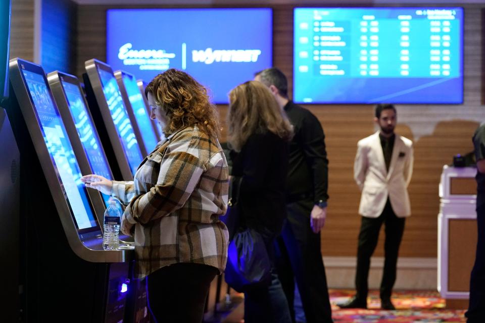 Patrons, left, place sports bets at kiosks at Encore Boston Harbor casino Tuesday in Everett. Massachusetts sports fans who want to wager on their favorite teams are finally getting their chance as the state kicks off sports betting at casinos in the state beginning Tuesday.