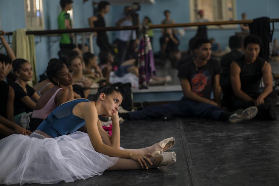 Members of the national ballet of Cuba stretch while they watch a rehearsal directed by Viengsay Valdes in Havana, Cuba, Thursday, Dec. 12, 2019. Valdes, the new head of Cuba's legendary National Ballet, says she hopes to renew the institution after the death of long-time director Alicia Alonso by introducing new choreography and appearances by dancers who have emigrated to other companies. (AP Photo/Ramon Espinosa)