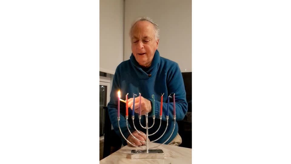 Richard Sills says a blessing as he lights the menorah in his Seattle home. - Courtesy Richard Sills