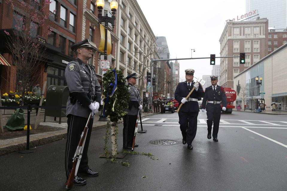 Boston Fire Department honor guards (R) relieve Cambridge Police honor guards at the site of one of the two bomb blasts on the one-year anniversary of the 2013 Boston Marathon bombings in Boston, Massachusetts, April 15, 2014. (REUTERS/Dominick Reuter)